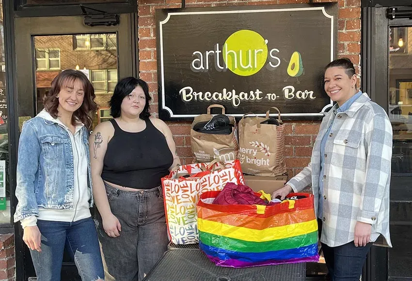 Lacey Pratt (l), Kayla Paredes (r), and Arthur's staff with clothes for pickup – Photo by Daniel Lindsley